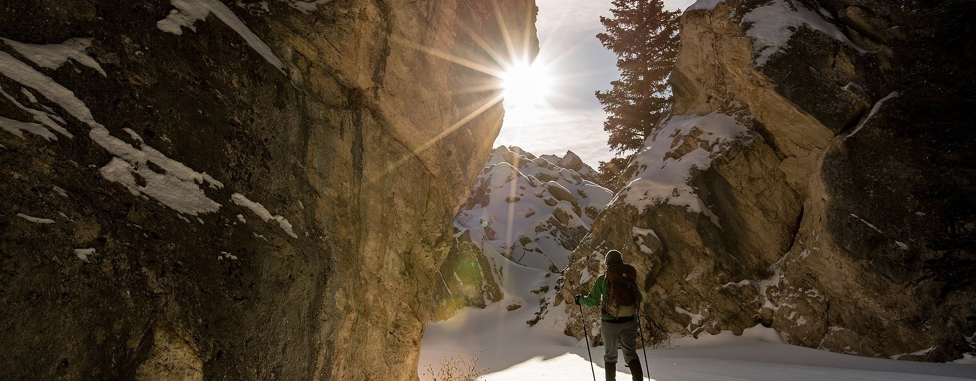 Skitouren-Wanderin im Tiefschnee mit untergehender Sonne